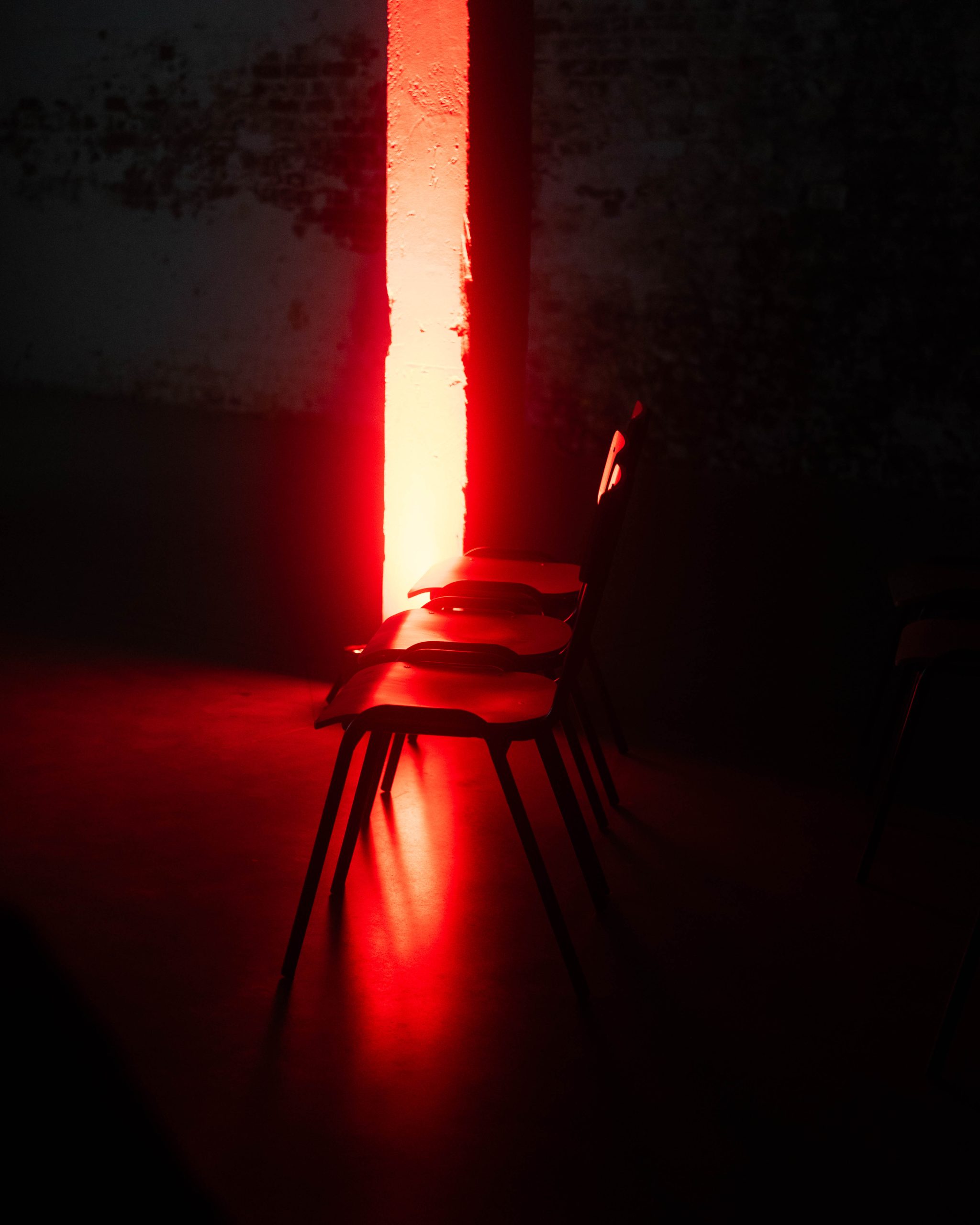 three chairs are illuminated by a bright red light